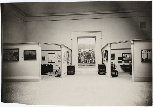The exhibit reveals an interior view of two of the four domestic “rooms” at the International Exhibition of Modern Art, Brooklyn Museum.