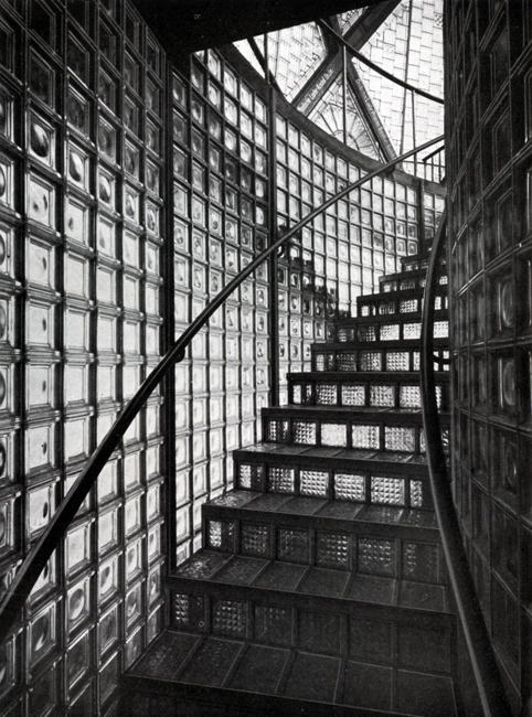 The exhibit showcases the interior stairs of Bruno Taut’s Glashaus. The stairs run between glass structures that resemble walls composed of intricately assembled square shapes, creating a visually stunning design that allows natural light to permeate from the outside.