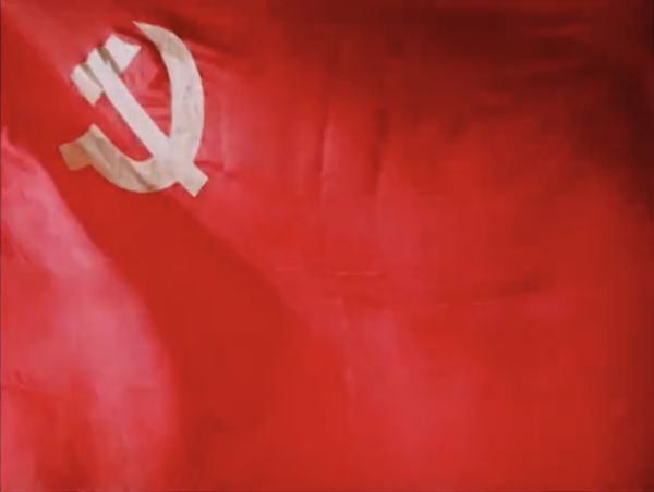 Red flag with hammer and sickle in corner.
