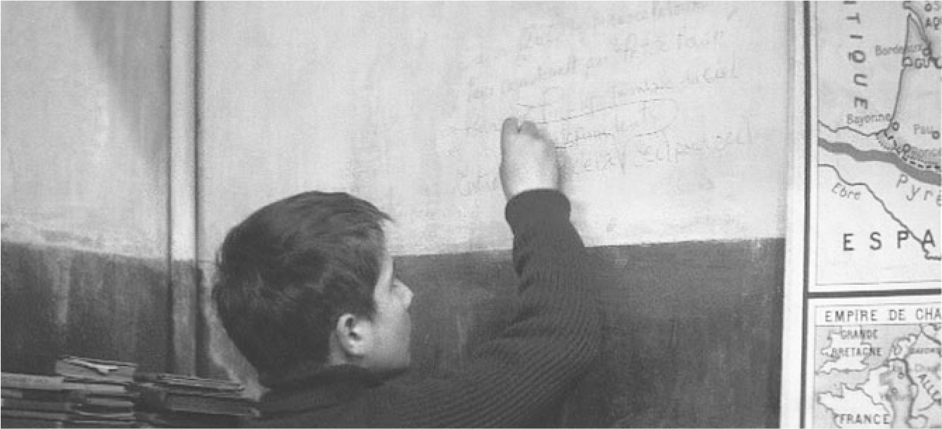 In a scene from the movie “Les 400 coups,” the character Doinel wrting on the board next to a map.