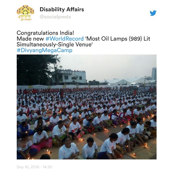 A tweet from the Department of Disability Affairs with a photograph of Indian disabled people sitting in long rows with oil lamps in front of them.