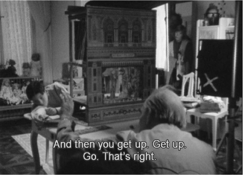 The exhibit captures Ingmar Bergman directing actors on the set of “Fanny and Alexander.” He is in conversation with the actor playing Alexander. The text on the frame reads, “And then you get up. Get up. Go. That’s right.”