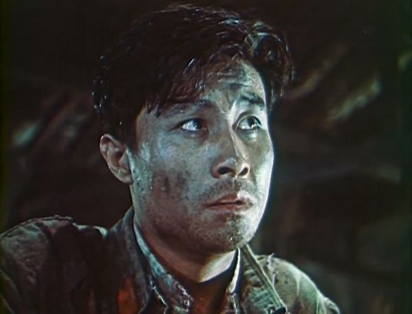 Clos-up on the pensive face of a young man; he is sweating and has dirt on his cheek.