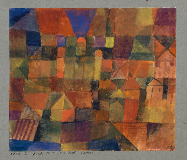 The exhibit showcases a whimsical townscape painted by Paul Klee, featuring a riot of vibrant colors, geometric shapes, prominent floating domes, and playful houses with a dreamlike quality.