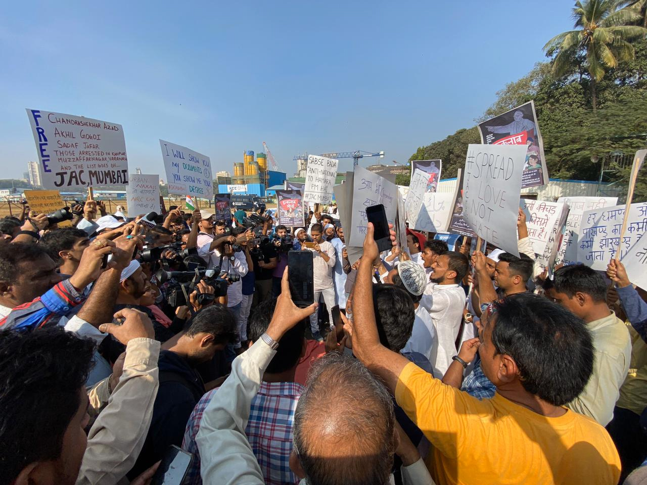 Protesters hold up handmade signs and phones.