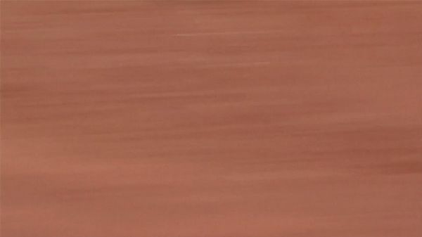 Video still of iron-rich earth distorted by motion blur into orange-brown streaks.