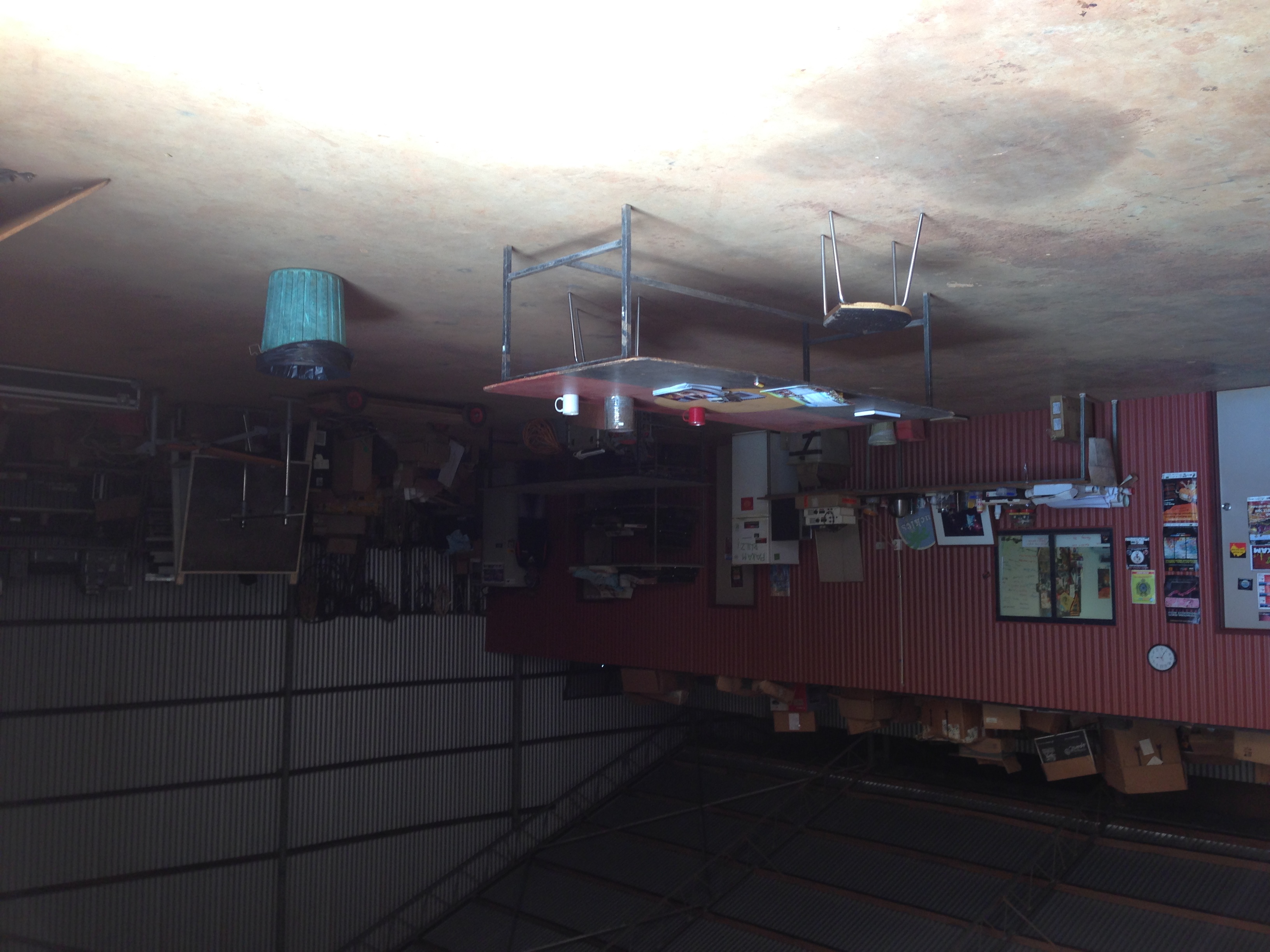 Light from the large open shed door illuminates the central PAKAM table in the middle of a large area outside of Neil’s office.