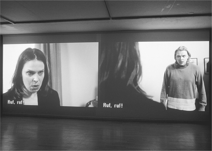 A photograph of dual screens mounted next to each other, with one showing the front view and the other shows the rear view of the same picture.