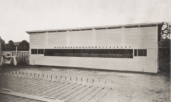 A one-story wooden structure with a wide viewing pane cut into its side. The viewing pane is sectioned into twenty-eight numbered sections.