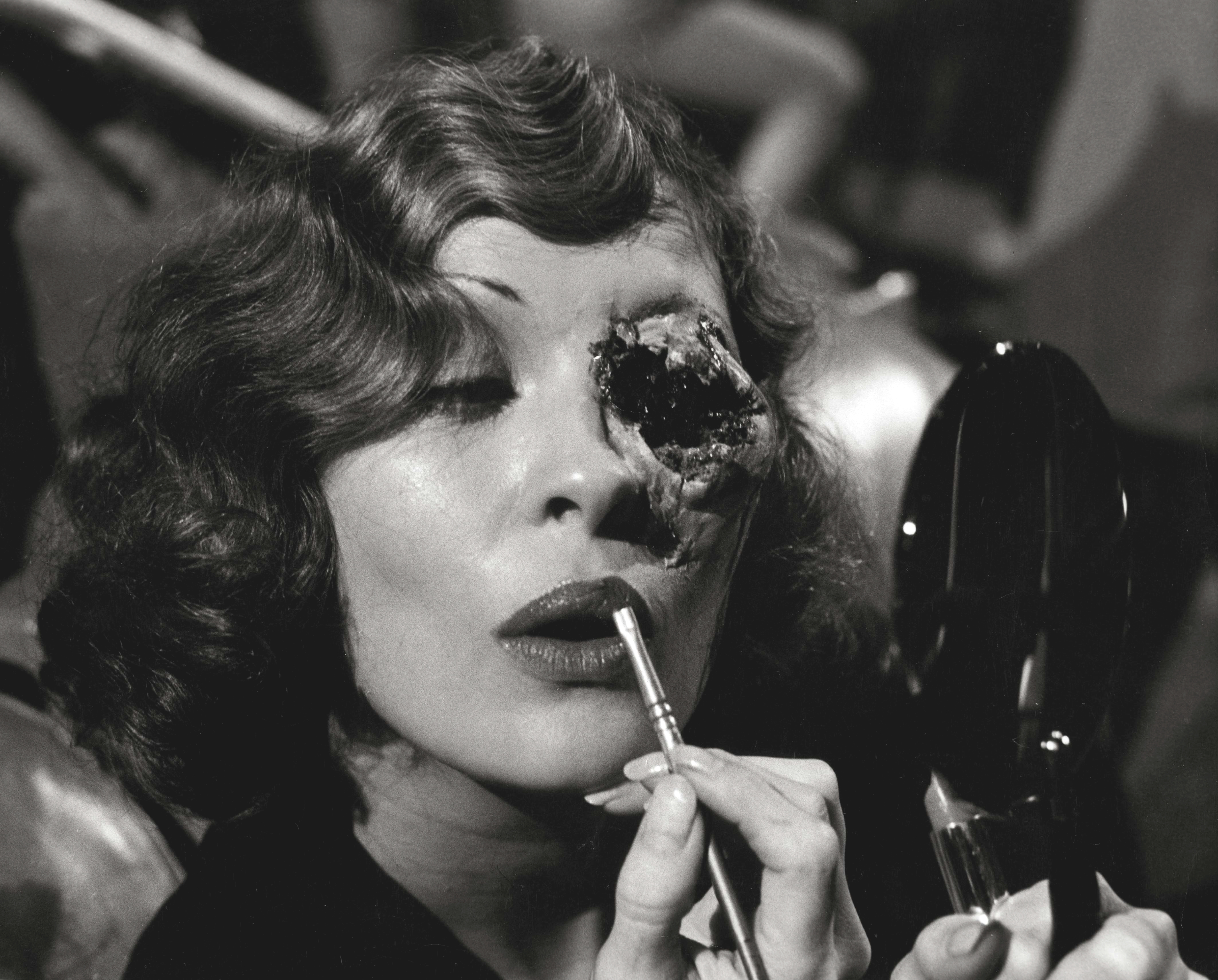 Faye Dunaway on set touching up her makeup while wearing the special effects makeup for the bullet wound in Evelyn Mulwray’s eye.
