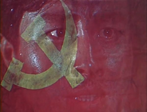 Still showing a fade transition between the young man’s face and the Soviet flag.