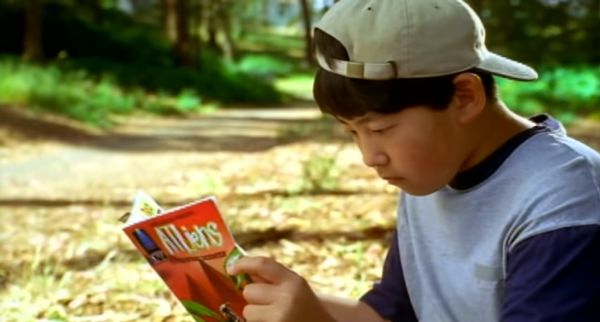 Middle school–aged boy reading a comic book.