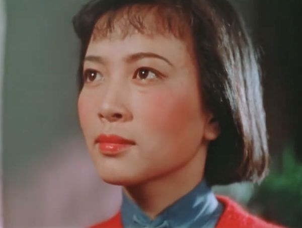 Close up of young woman in orange sweater.
