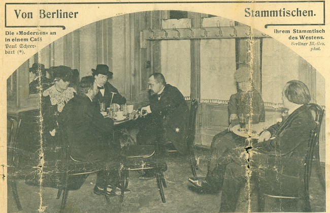 The exhibit showcases a photograph capturing two women and four men seated in a café, all dressed in formal attire.