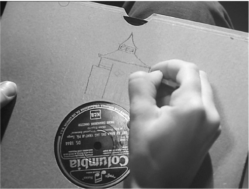 The exhibit features a still from the movie depicting a perspective view of a character drawing on the cover of a music record.