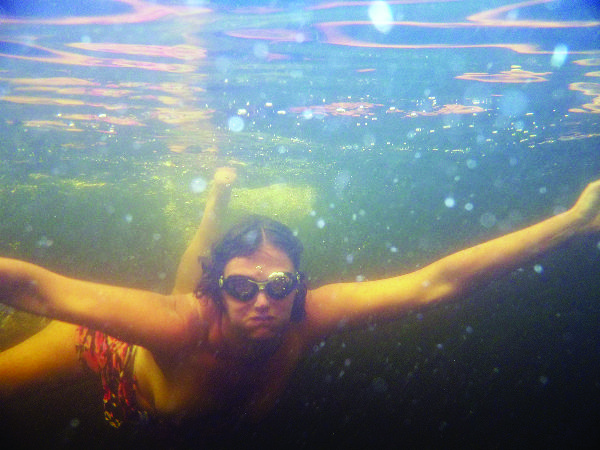 Underwater shot of a person swimming toward the camera.