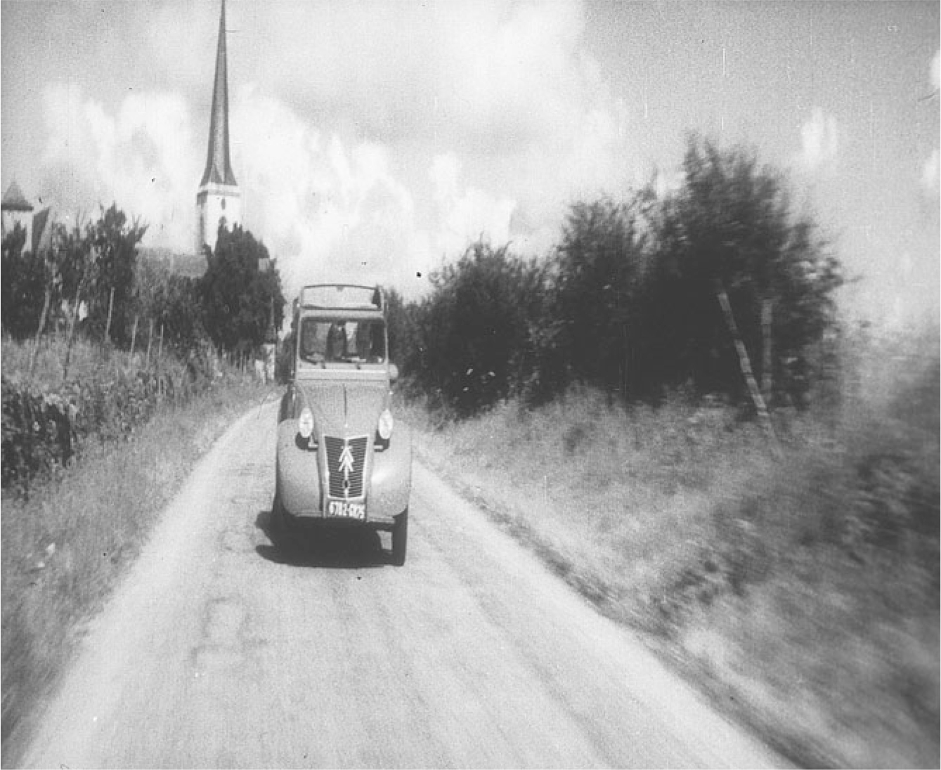 The exhibit shows a scene from “Les Amants” featuring the front view of a car moving along a contry side road.