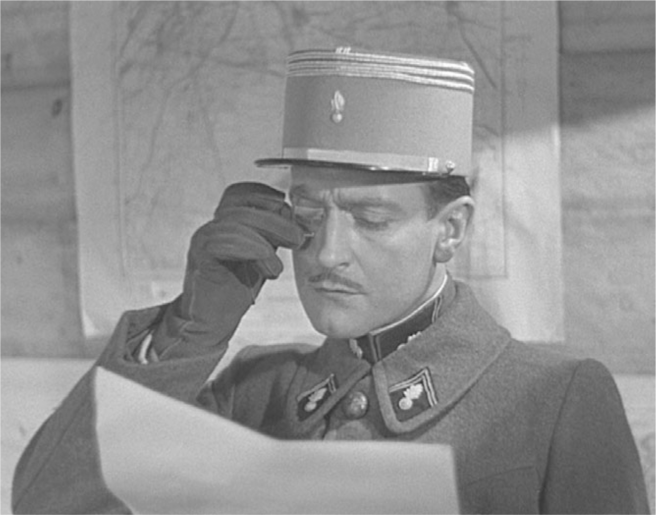 The exhibit illustrates a scene from “La Grande Illusion” where a man in military uniform, Boëldieu, stands before two military maps, scrutinizing and casting aspersions on a map.