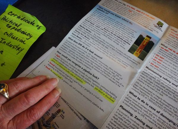 Participant showing brochure for detecting and reporting a gas pipeline leak.