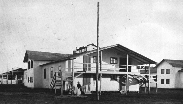 Side view of a two story building showing stairs leading to a second floor deck.