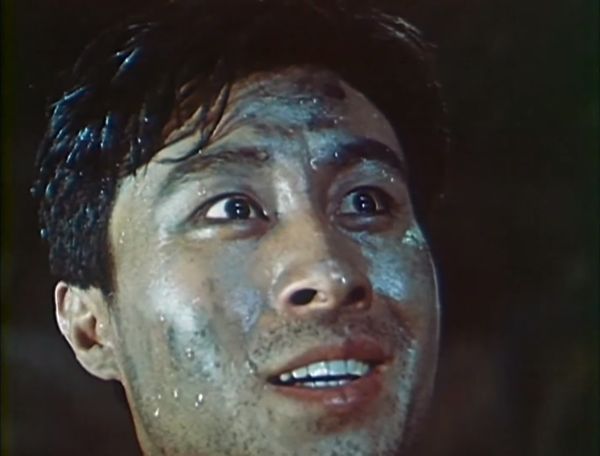 Close-up from a different angle on the face of the young man who is now smiling.