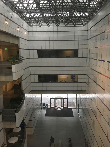 A view from the third-story landing of an open-air atrium within a building.
