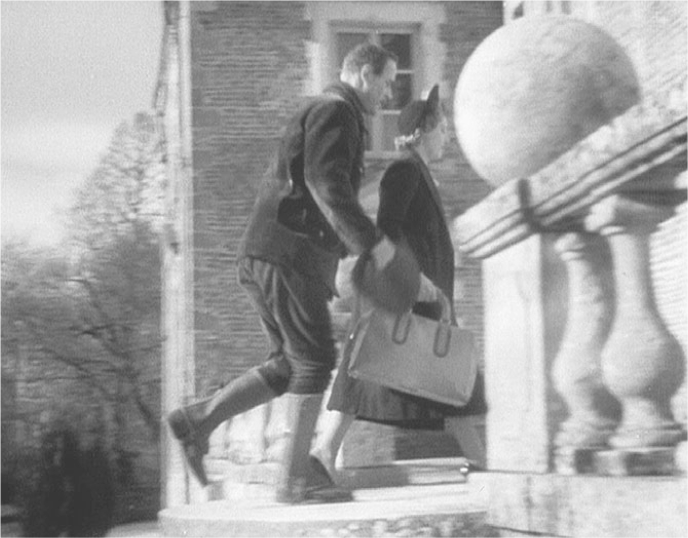 The exhibit depicts a scene from the movie “La Règle du jeu” where a male and a female character are observed entering a building.