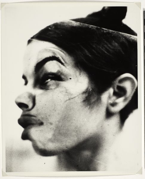 Side view of a woman's face pressed up against glass, emphasizing her left eye and side of her mouth