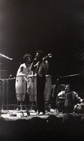 Black-and-white photo of three men standing on stage