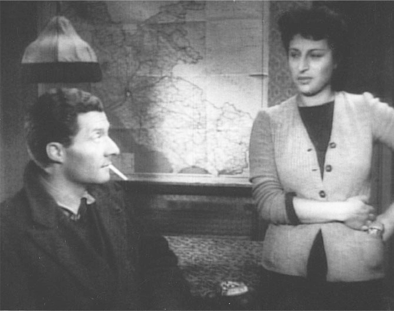 The exhibit features a scene from “Roma, città aperta,” where Manfredi, positioned under a lampshade, engages in a conversation with Pina in her apartment.