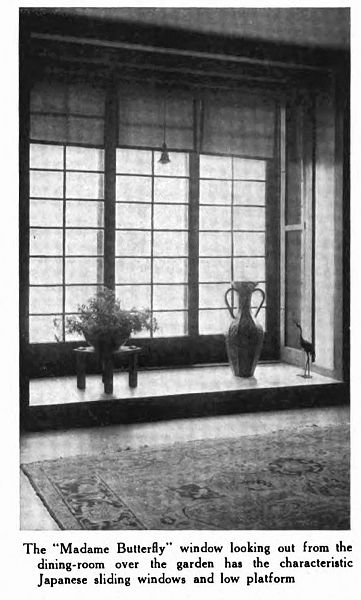 A window in an alcove with a plant and a vase on the sill. The panes are rectangular. In the foreground on the floor is a Persian rug.
