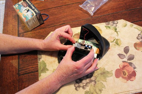 Participant inspecting internal electronics of Speck during setup at monitoring location.