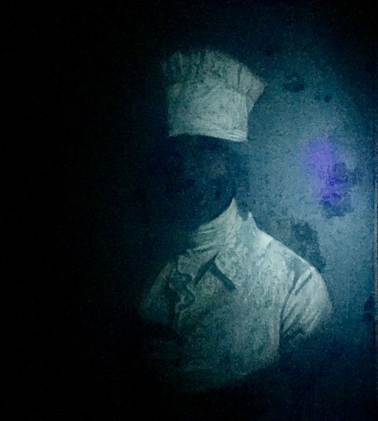 Painting of a faceless man in white chef's garb