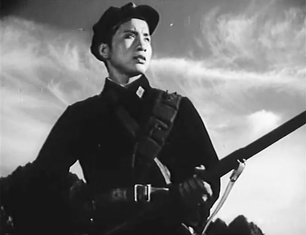 Young man in military uniform holding a rifle.