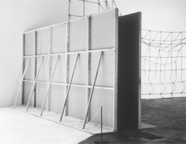 A photograph of the back view of a wooden corridor structure showing the balancing sticks at the back.