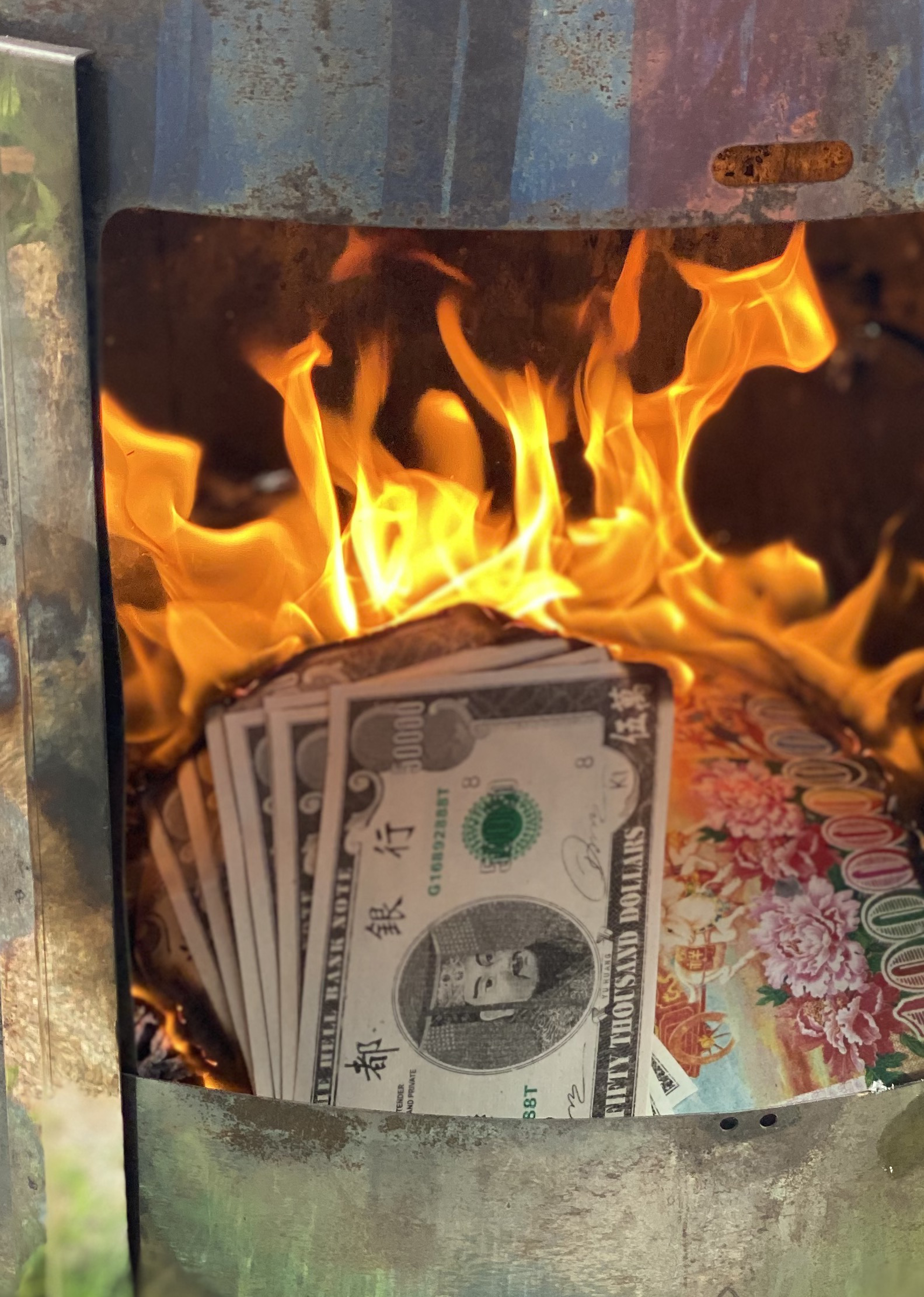 Paper money burns inside a brazier. The notes resemble American money, but with Chinese elements. The denomination is fifty thousand dollars.