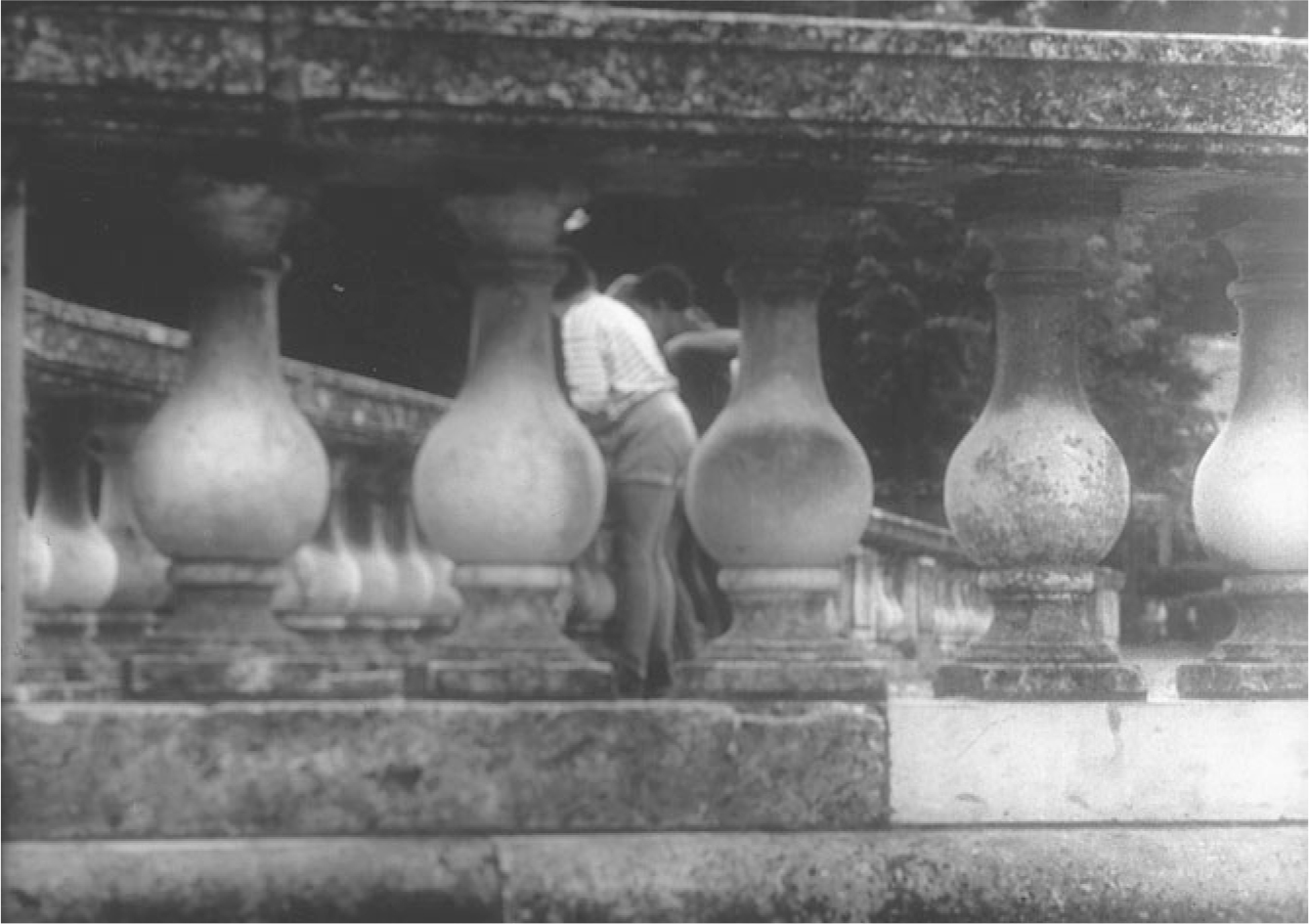 The exhibit displays a scene from “Les Mistons” where mischievous children are seen through a screen of balusters in a park.