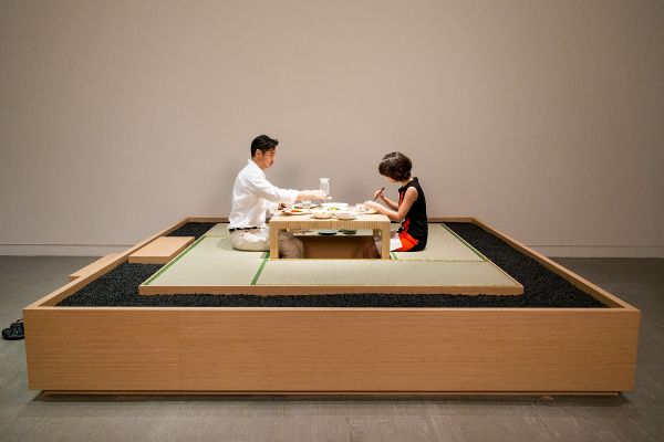A man and woman dining at the table bordered by a rock trough.
