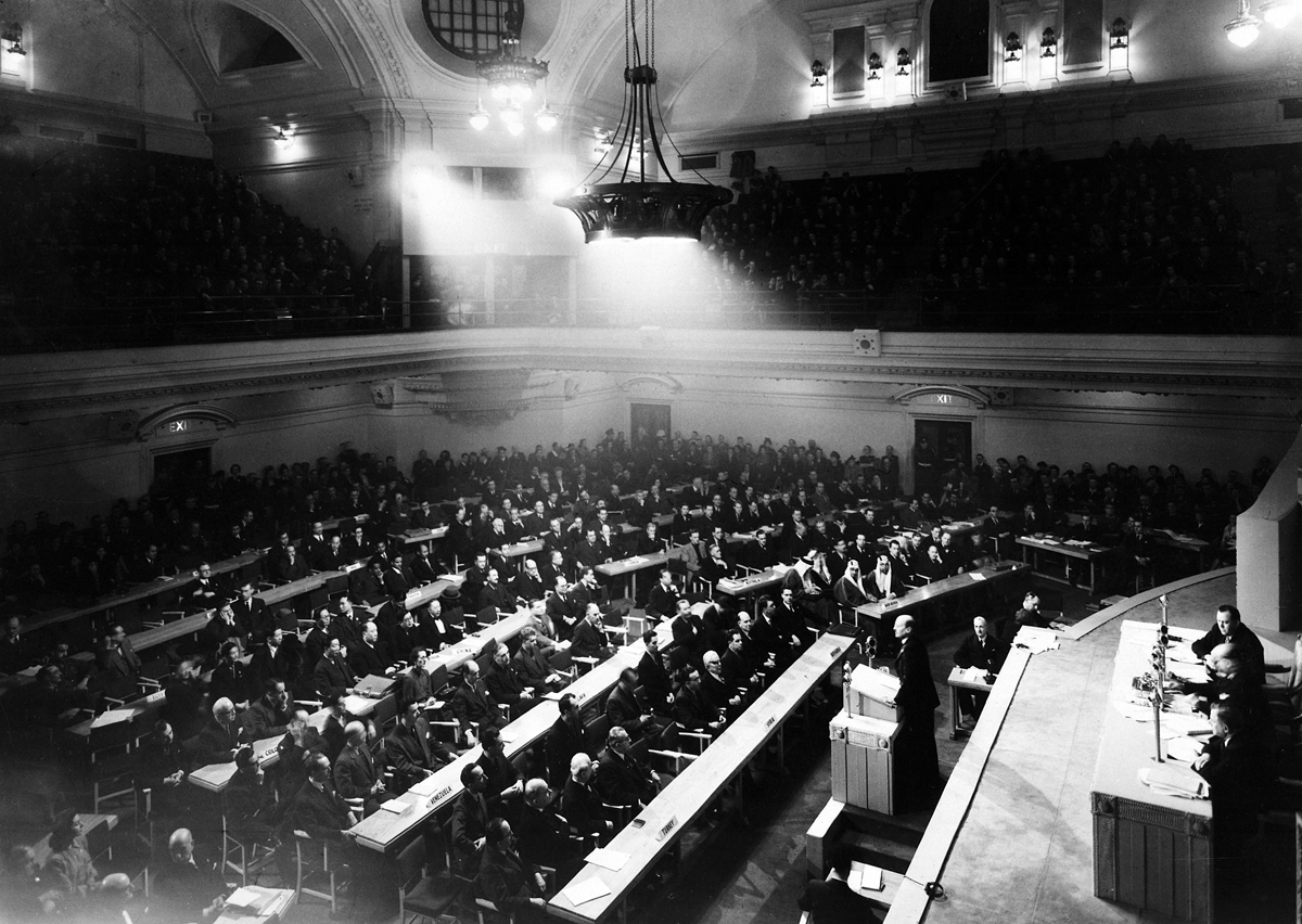 Photograph of assembly room looking toward a full auditorium with galleries.