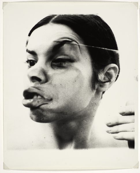 Woman's face pressed up against glass emphasizing her lips, cheek, and one eyebrow