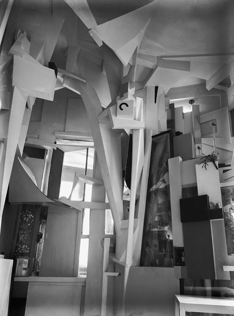 The exhibit showcases the intricately designed interior of Kurt Schwitters’ “Merzbau,” featuring a diverse array of abstract shapes.