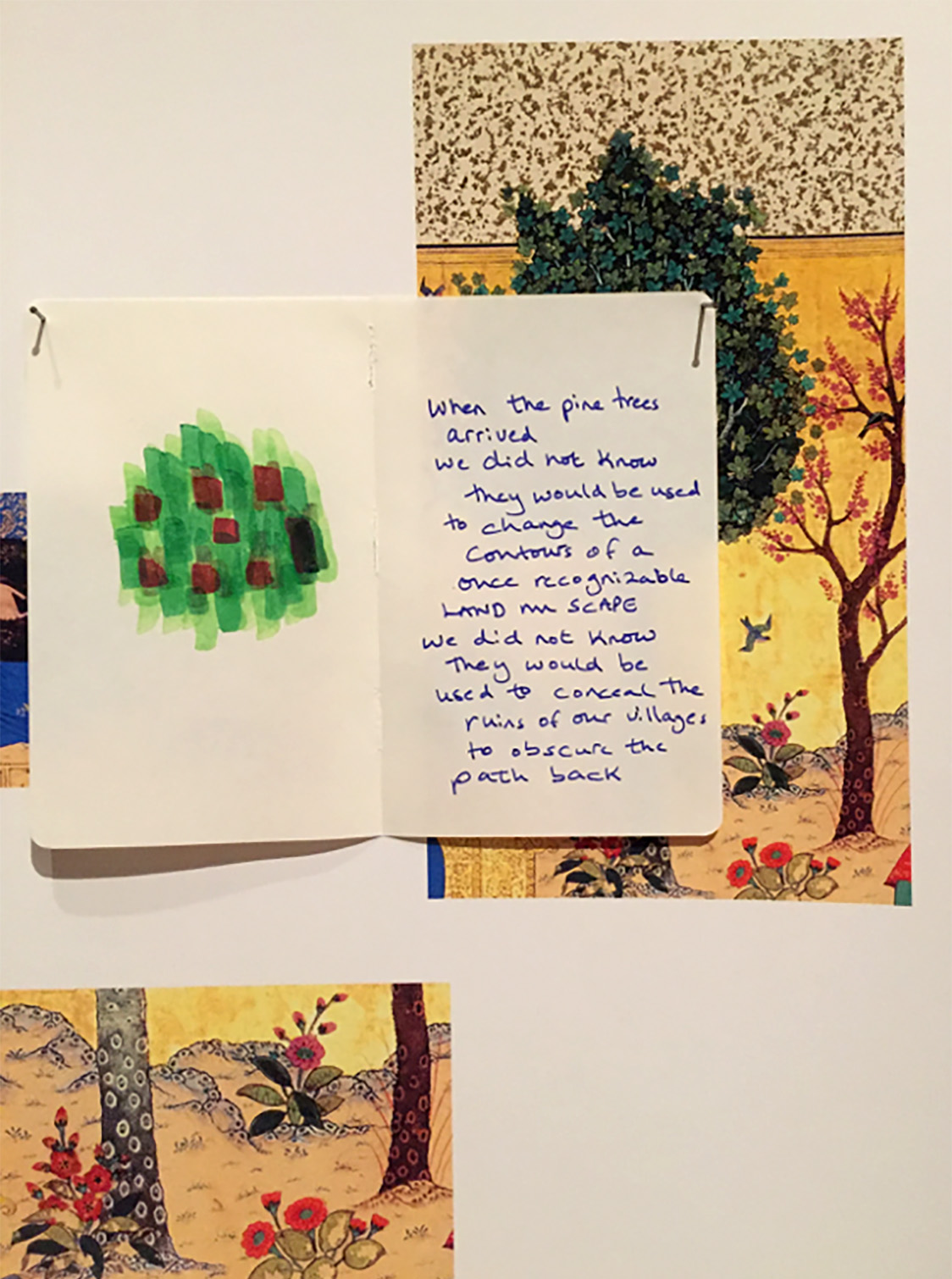 Close-up of an art installation showing drawings of trees and flowers. At center a drawing is paired with a short, written message.