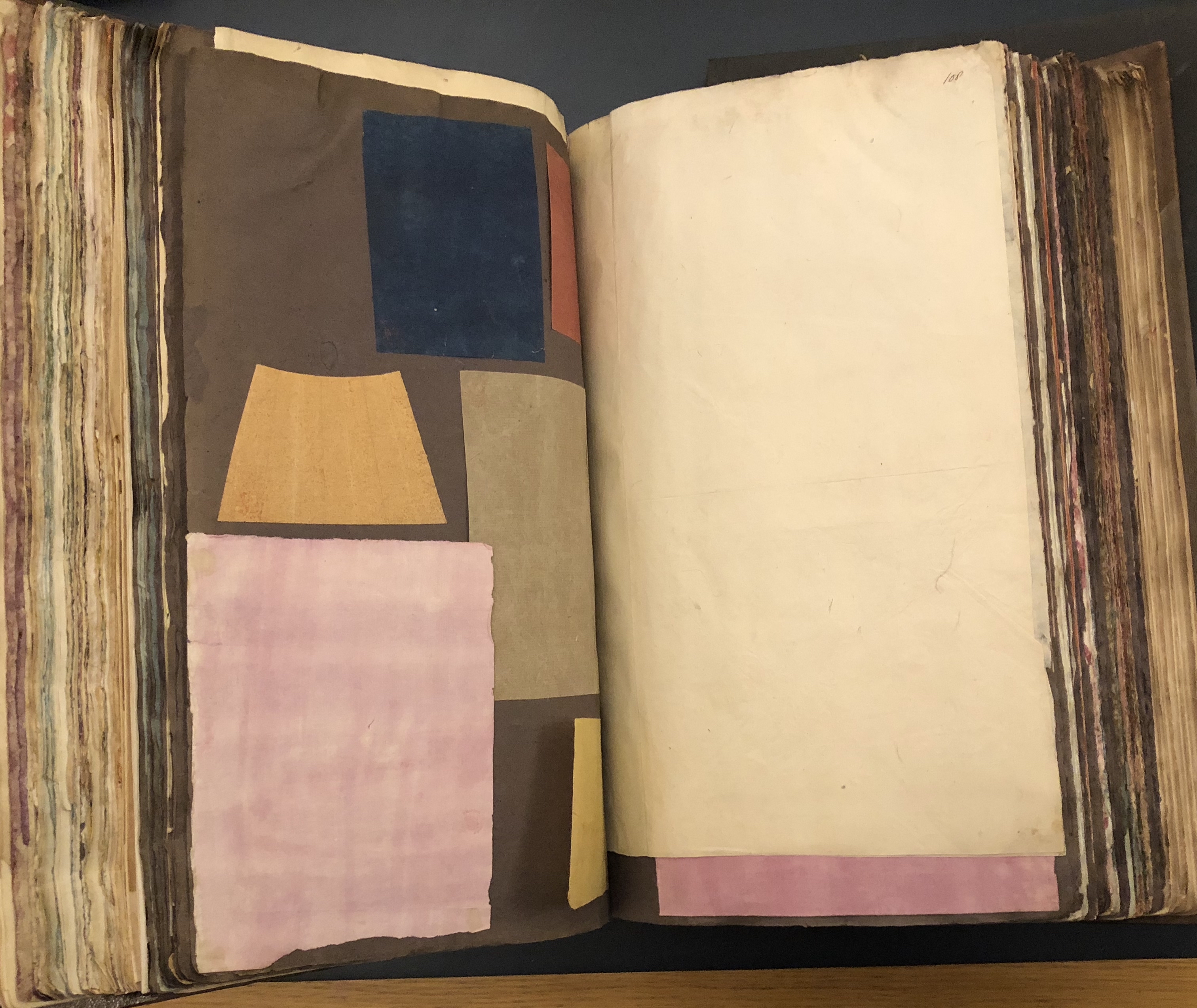 Photograph of colored papers pasted into a large volume of paper specimens