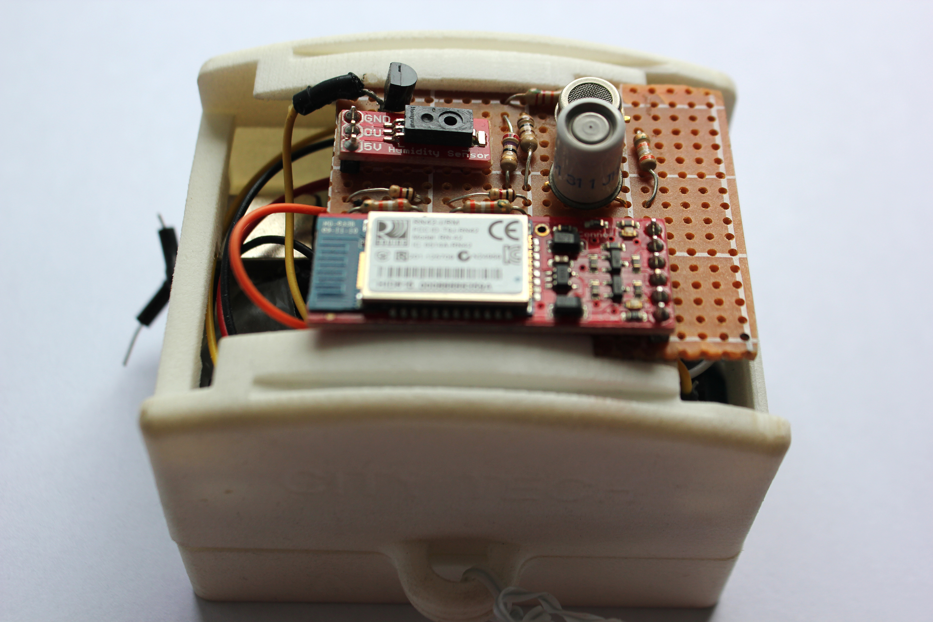 An open pale casing reveals electronic components, including circuit boards, wires, and sensors.